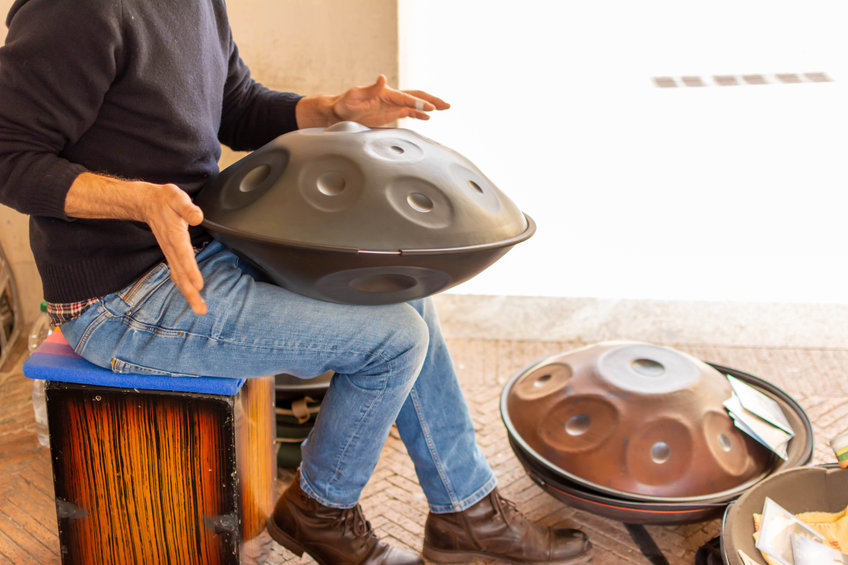 Musician Playing Handpan on Blurred Background